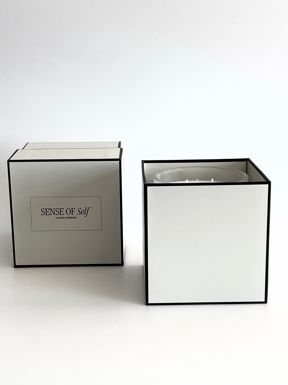 Sense of Self candle gift boxes with black borders on a white background